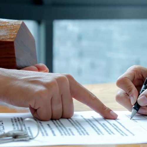 Close-up shot of The house broker pointed to the hand documents that customers signed a contract to buy a home loan.